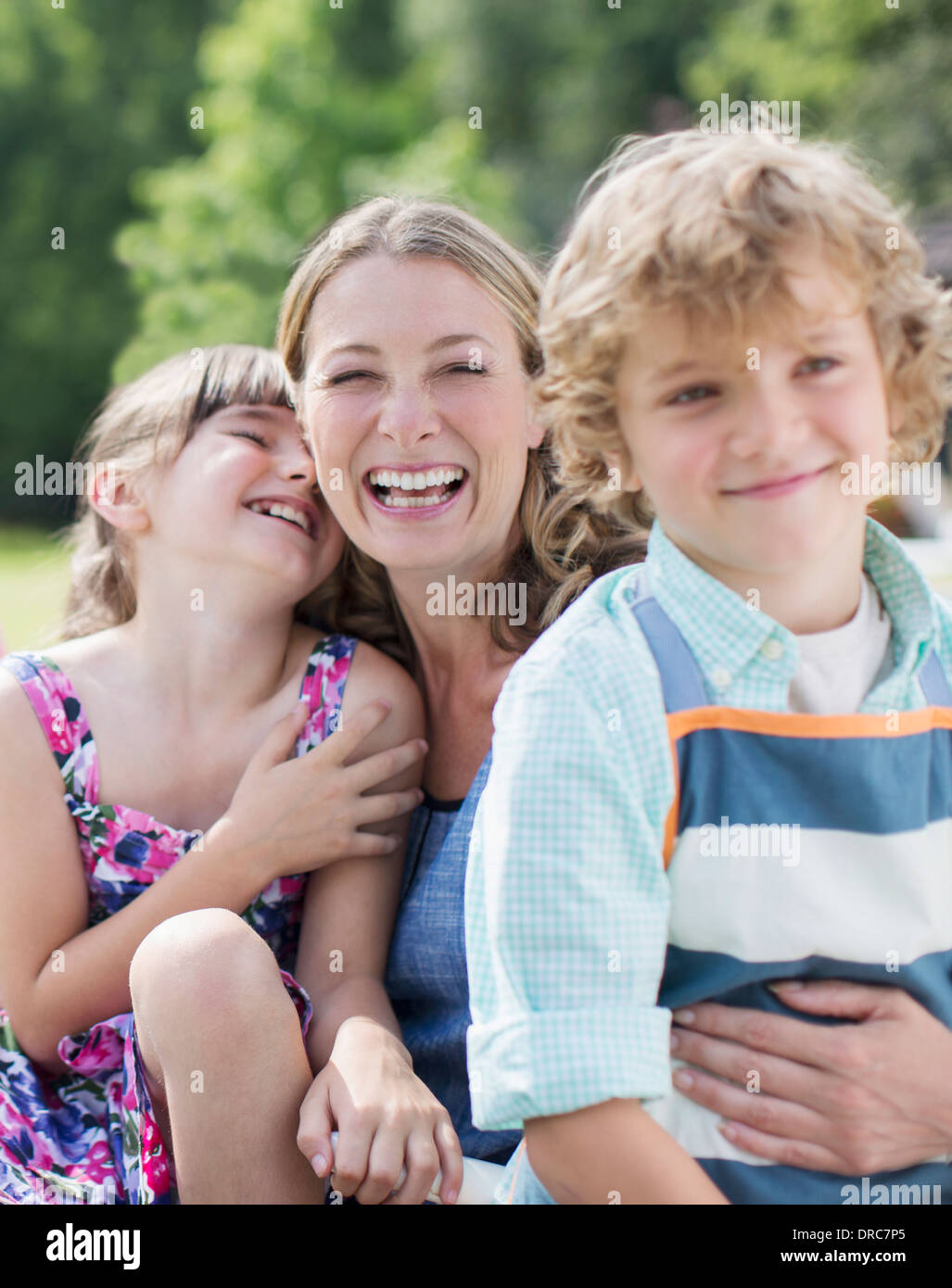 Madre e bambini sorridere all'aperto Foto Stock