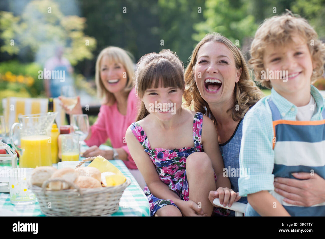 La famiglia a tavola in cortile Foto Stock