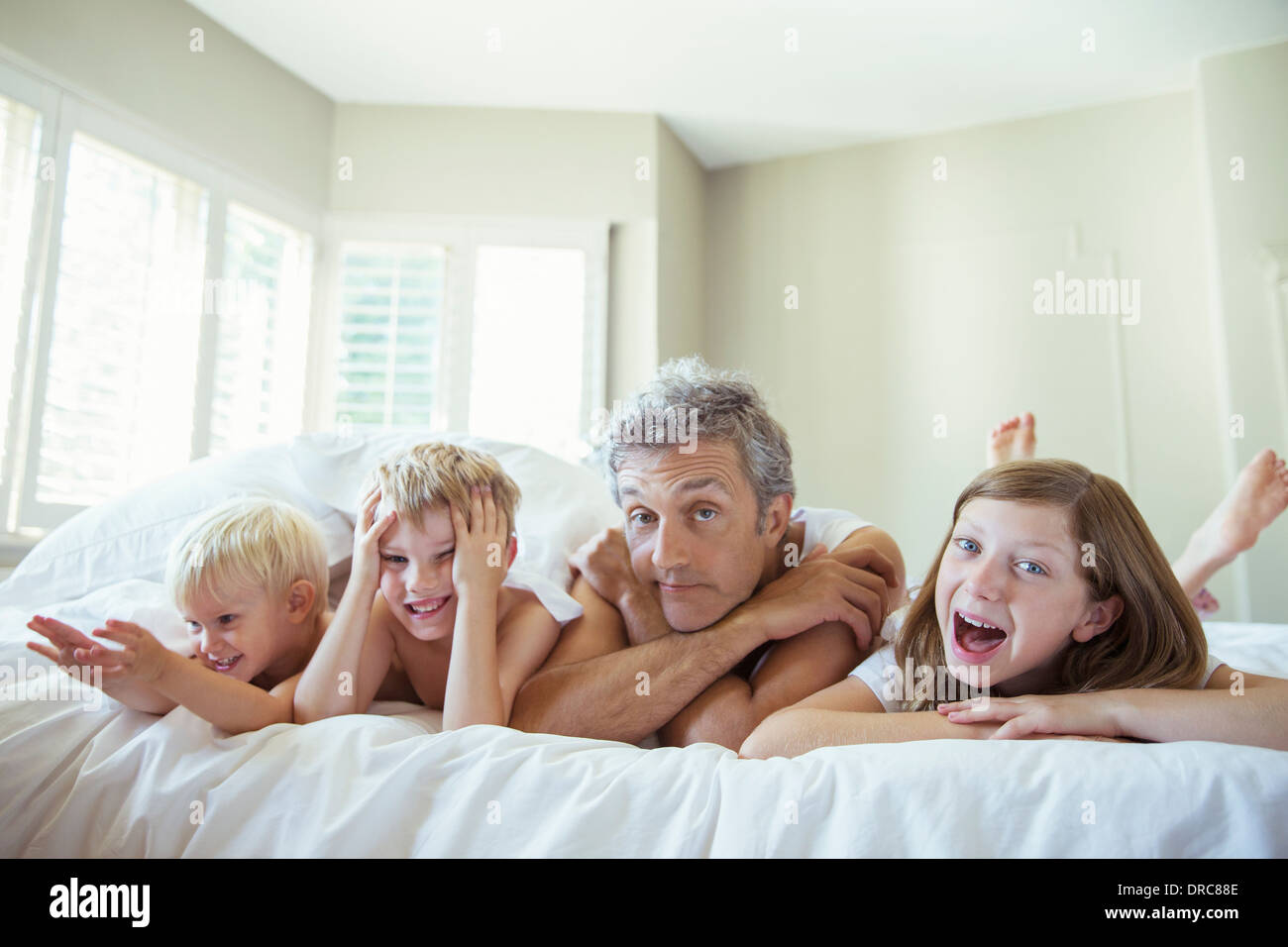 Padre e figli rilassante sul letto Foto Stock