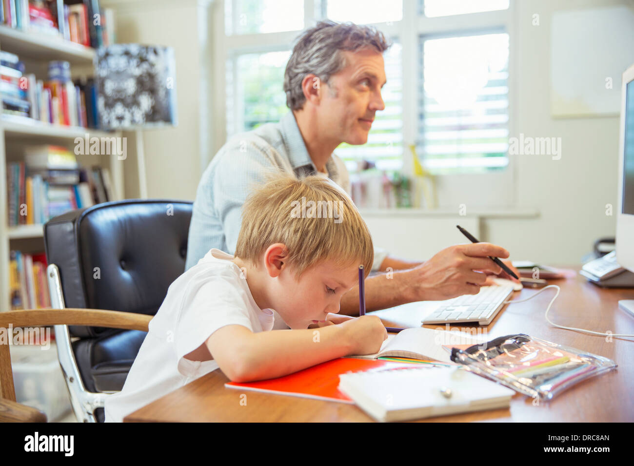 Padre e figlio che lavorano in ufficio in casa Foto Stock