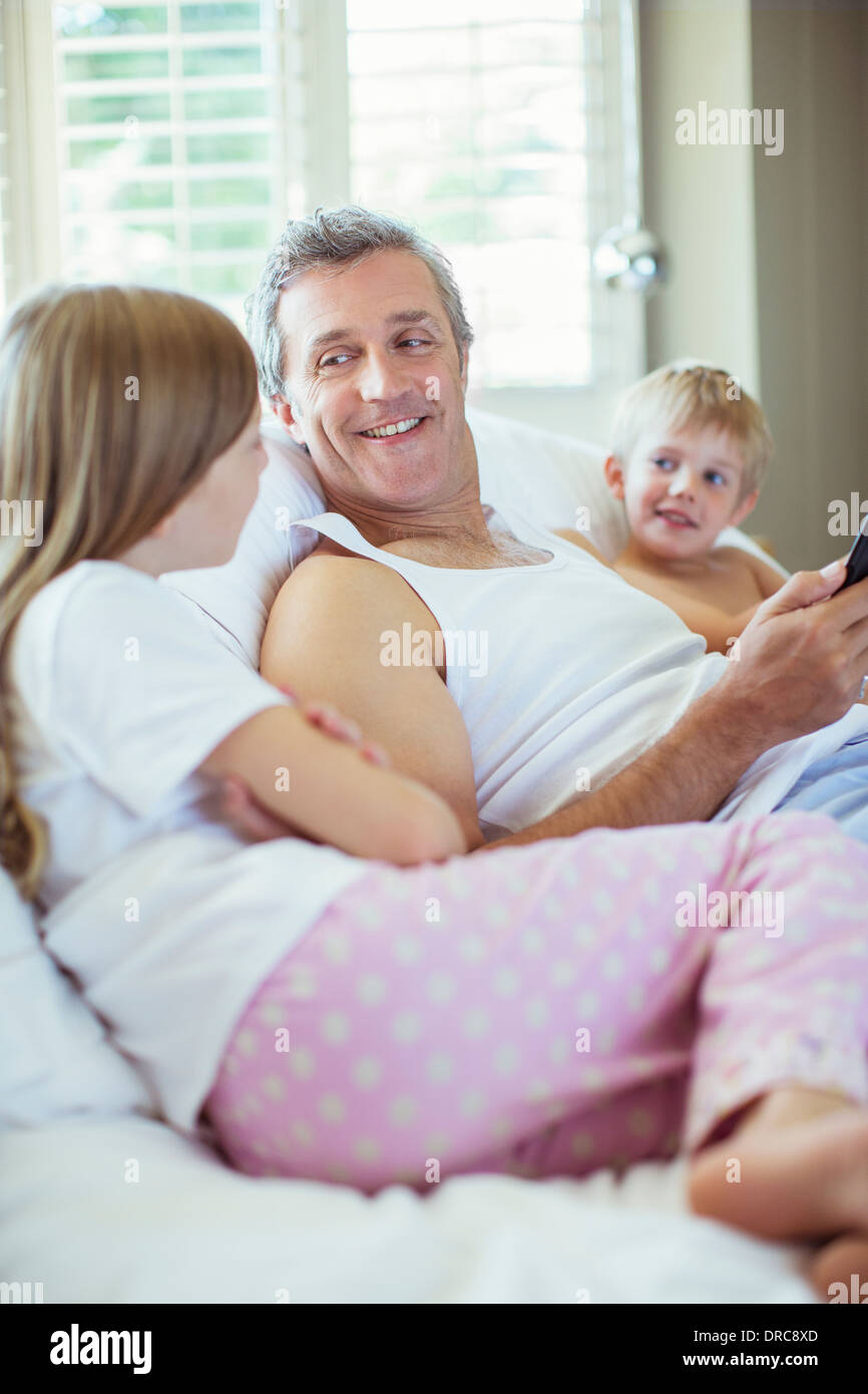 Padre e figli rilassante sul letto Foto Stock