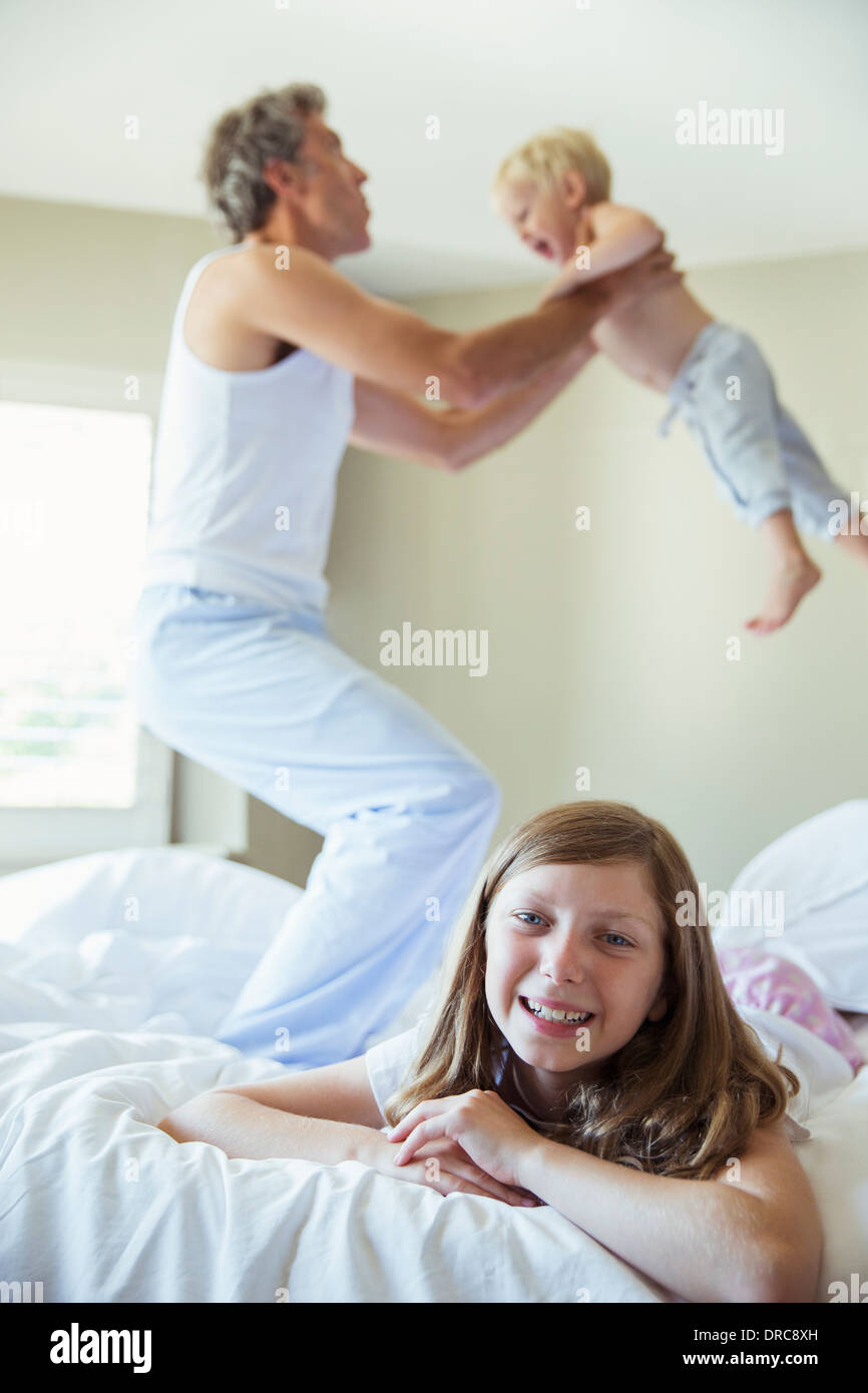 Padre e figli giocare sul letto Foto Stock