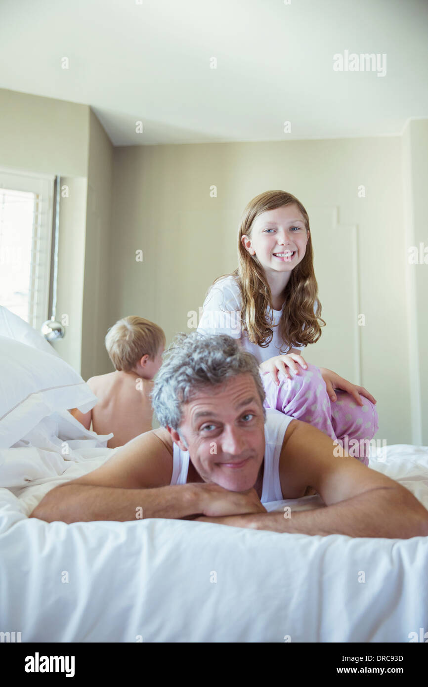 Padre a giocare con i bambini sul letto Foto Stock