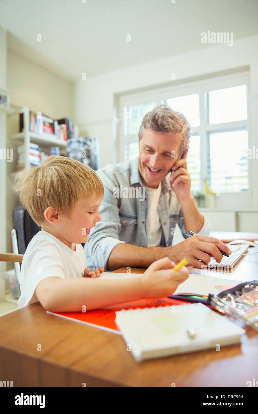 Padre e figlio che lavorano in ufficio in casa Foto Stock