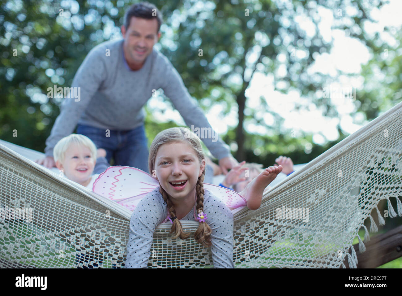 Padre e figli che stabilisce in amaca all'aperto Foto Stock