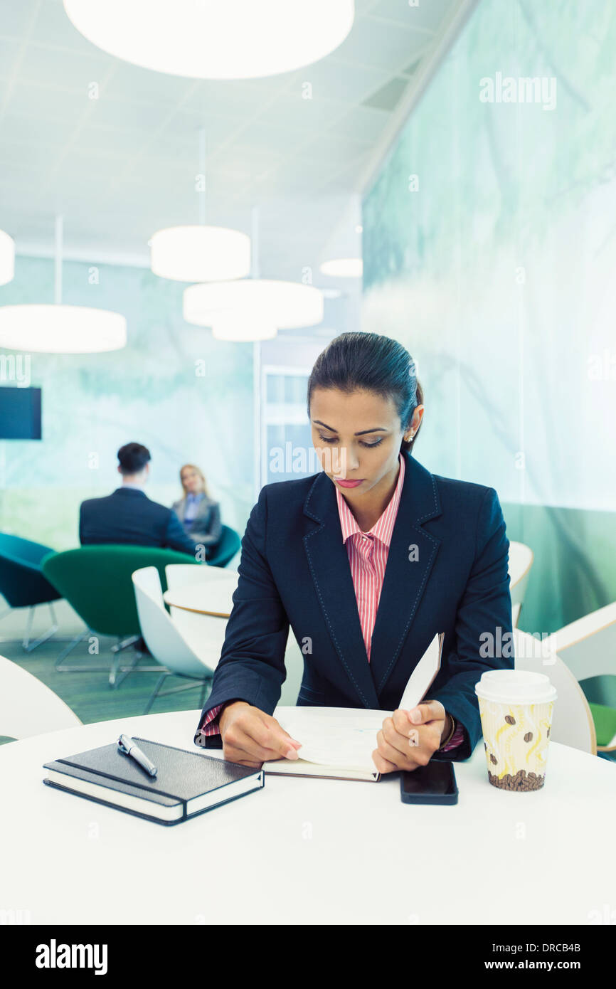 Imprenditrice lettura in cafe Foto Stock