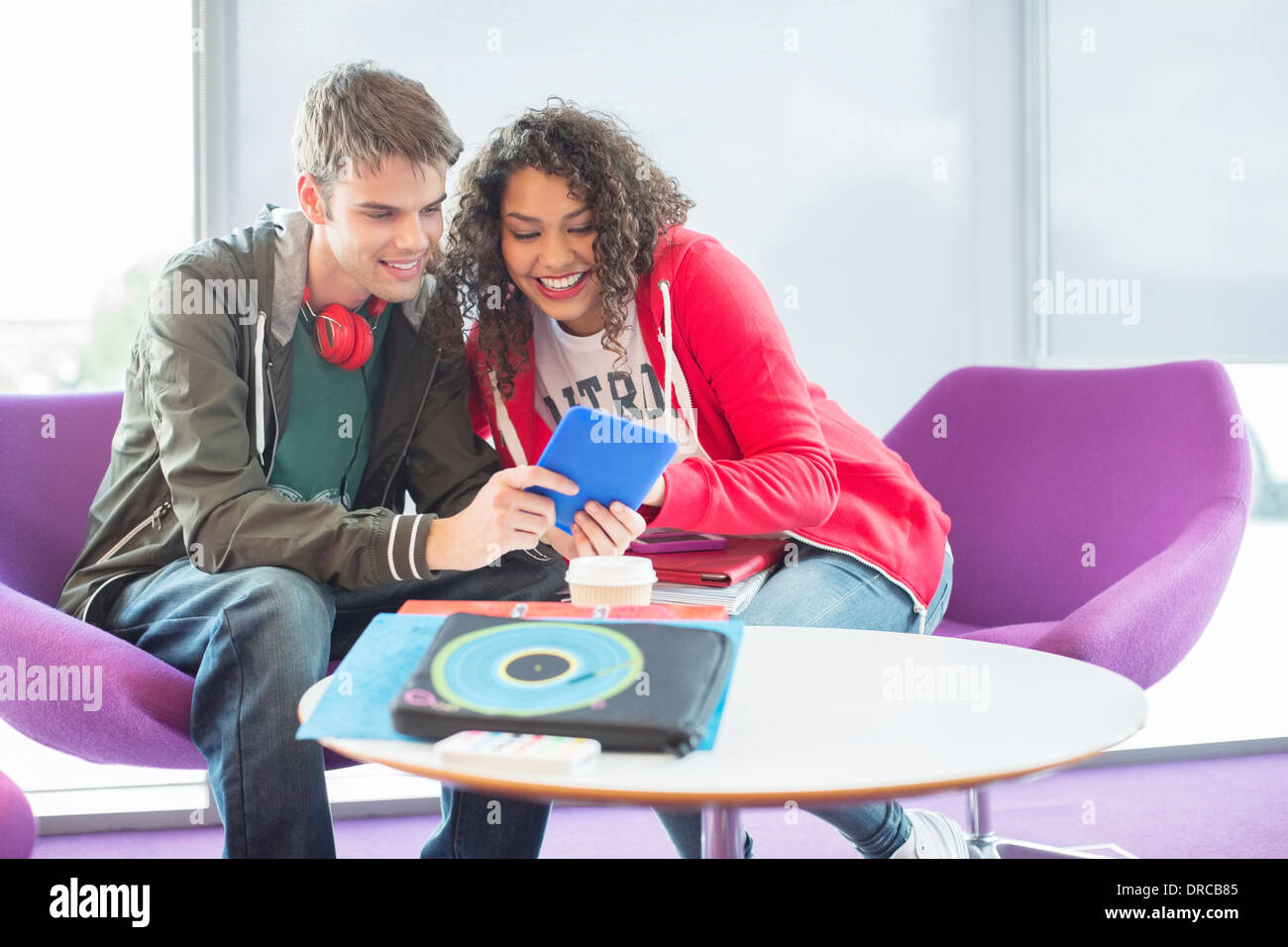 Gli studenti universitari con tavoletta digitale nella lounge Foto Stock