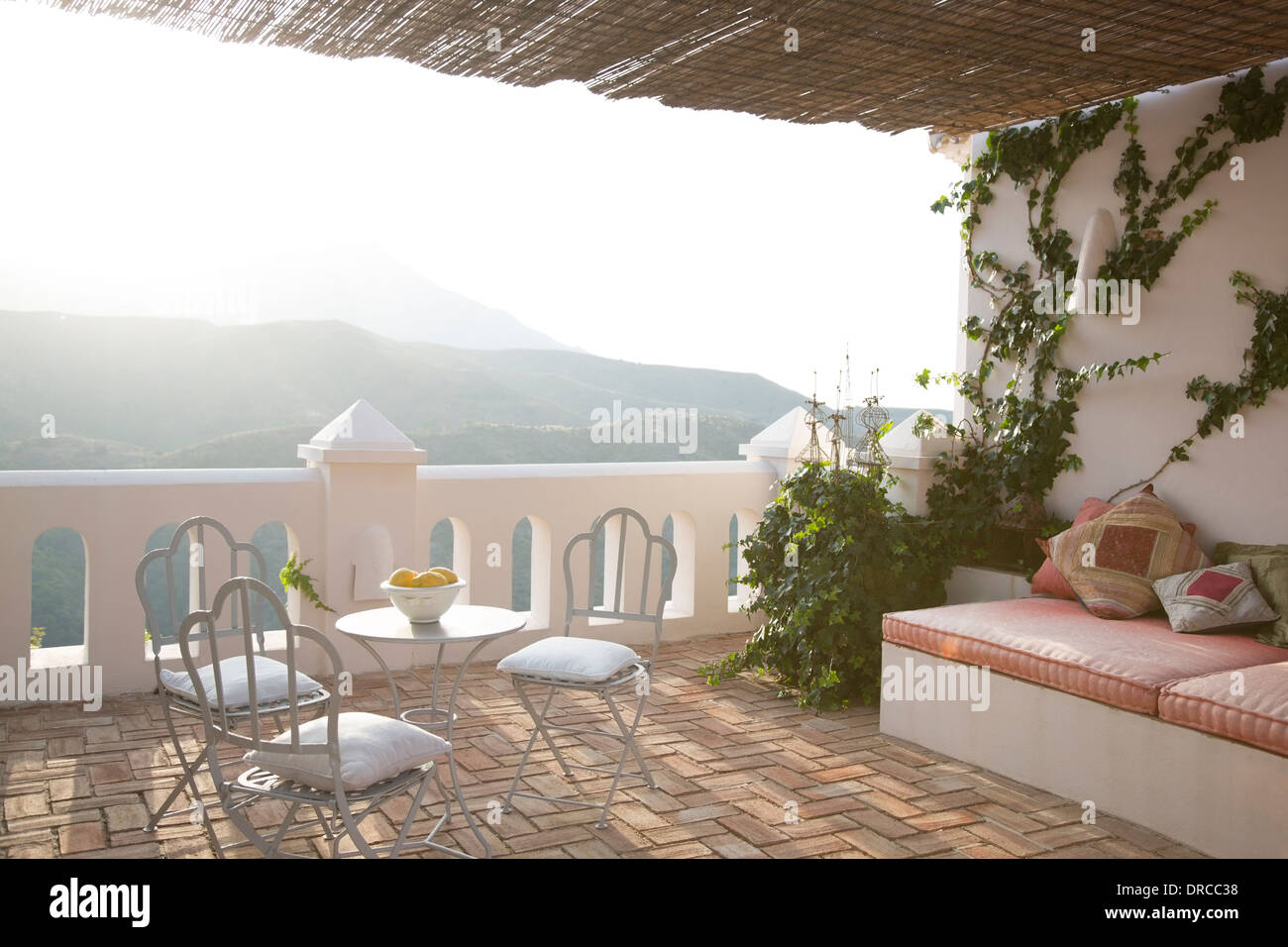 Tavolo e sedie sul balcone che affaccia sulle montagne Foto Stock