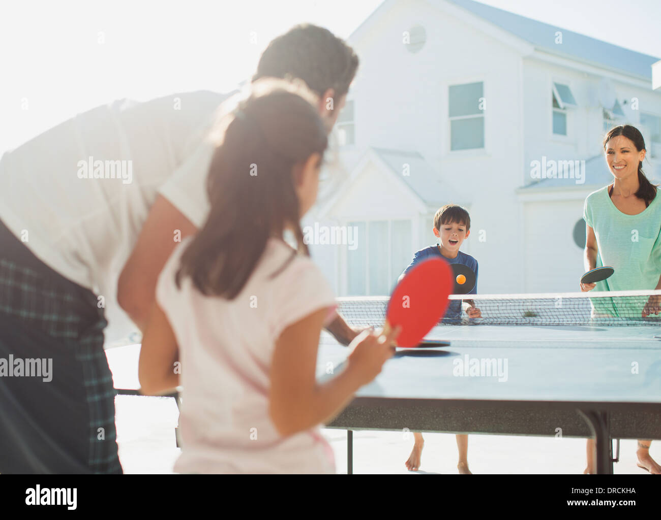 Famiglia giocando a ping-pong al di fuori casa Foto Stock