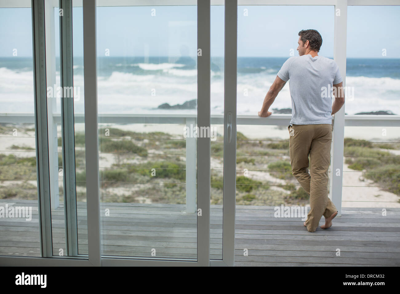 Uomo che guarda vista oceano dal deck Foto Stock