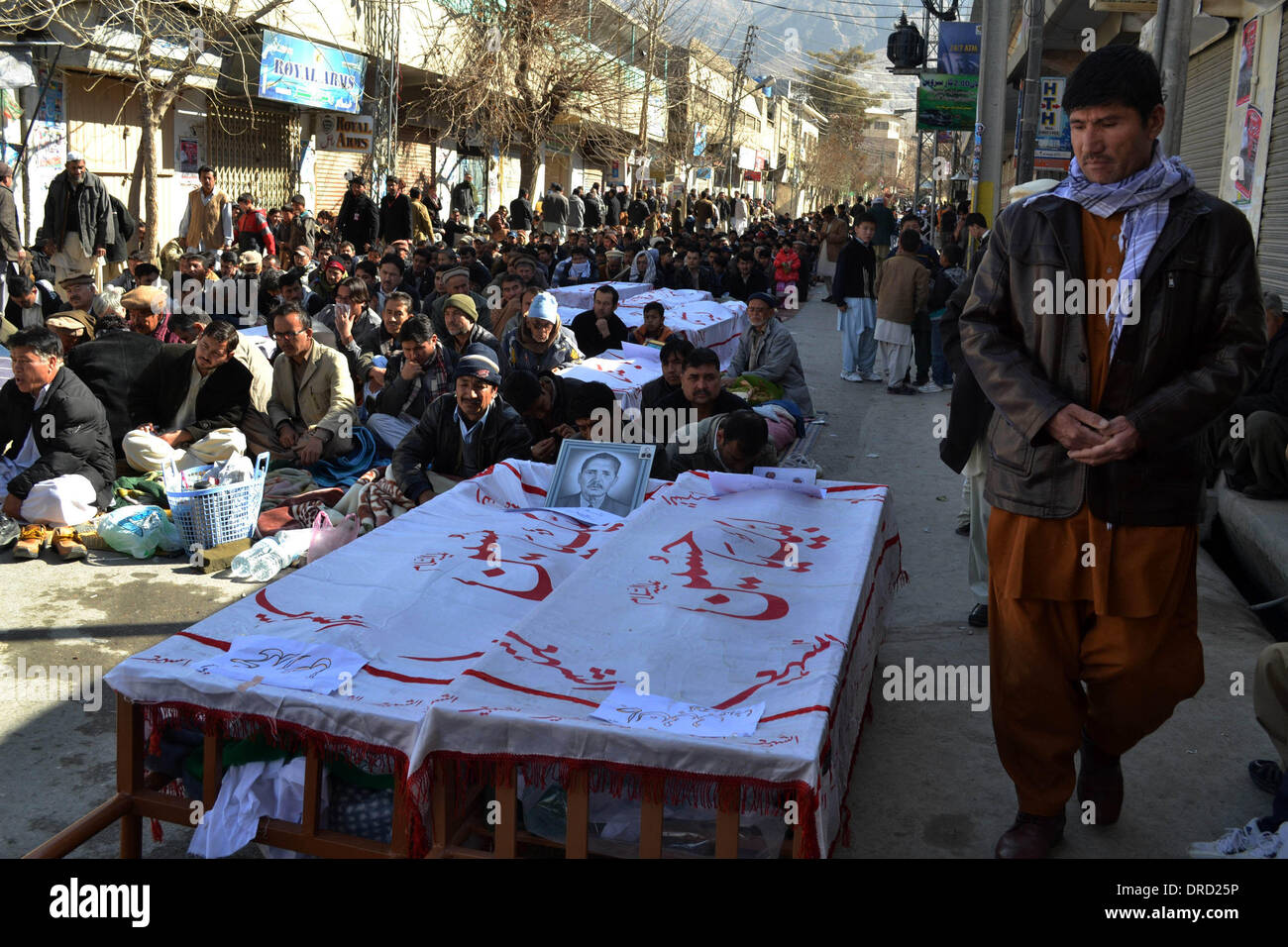 Quetta, Pakistan. 23 gen 2014. Il pakistan musulmani sciiti sedersi accanto a bare recanti i resti di coloro che sono morti in un bombardamento durante una manifestazione di protesta nel sud-ovest del Pakistan Quetta il 23 gennaio, 2014. Le proteste contro il martedì attentato suicida che ha ucciso 28 musulmani sciiti in Pakistan sudoccidentale della provincia di Balochistan continuato per il secondo giorno consecutivo in quasi tutte le grandi città del paese il giovedì. Credito: Asad/Xinhua/Alamy Live News Foto Stock