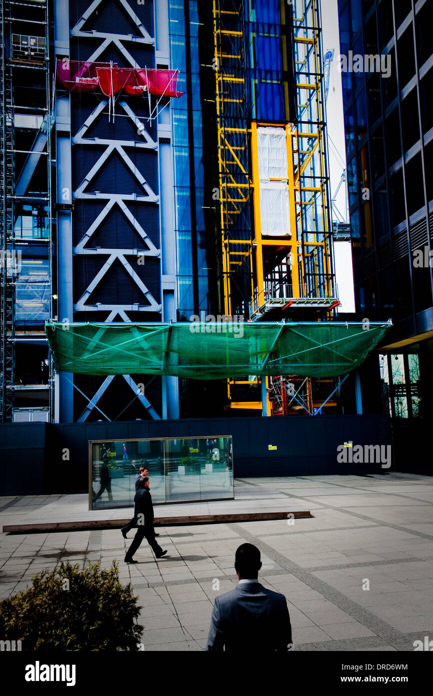 Nero lavoratore cittadino contro gli edifici colorati nella City di Londra Foto Stock
