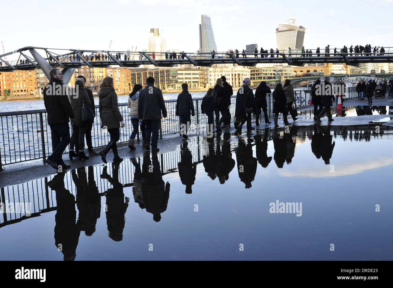 La riflessione di persone su un marciapiede in caso di forti piogge in Londra Foto Stock