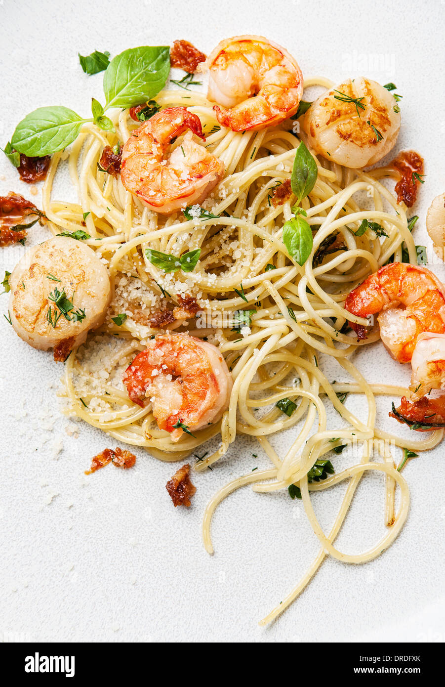 Spaghetti con gamberi e capesante di mare e basilico Foto Stock