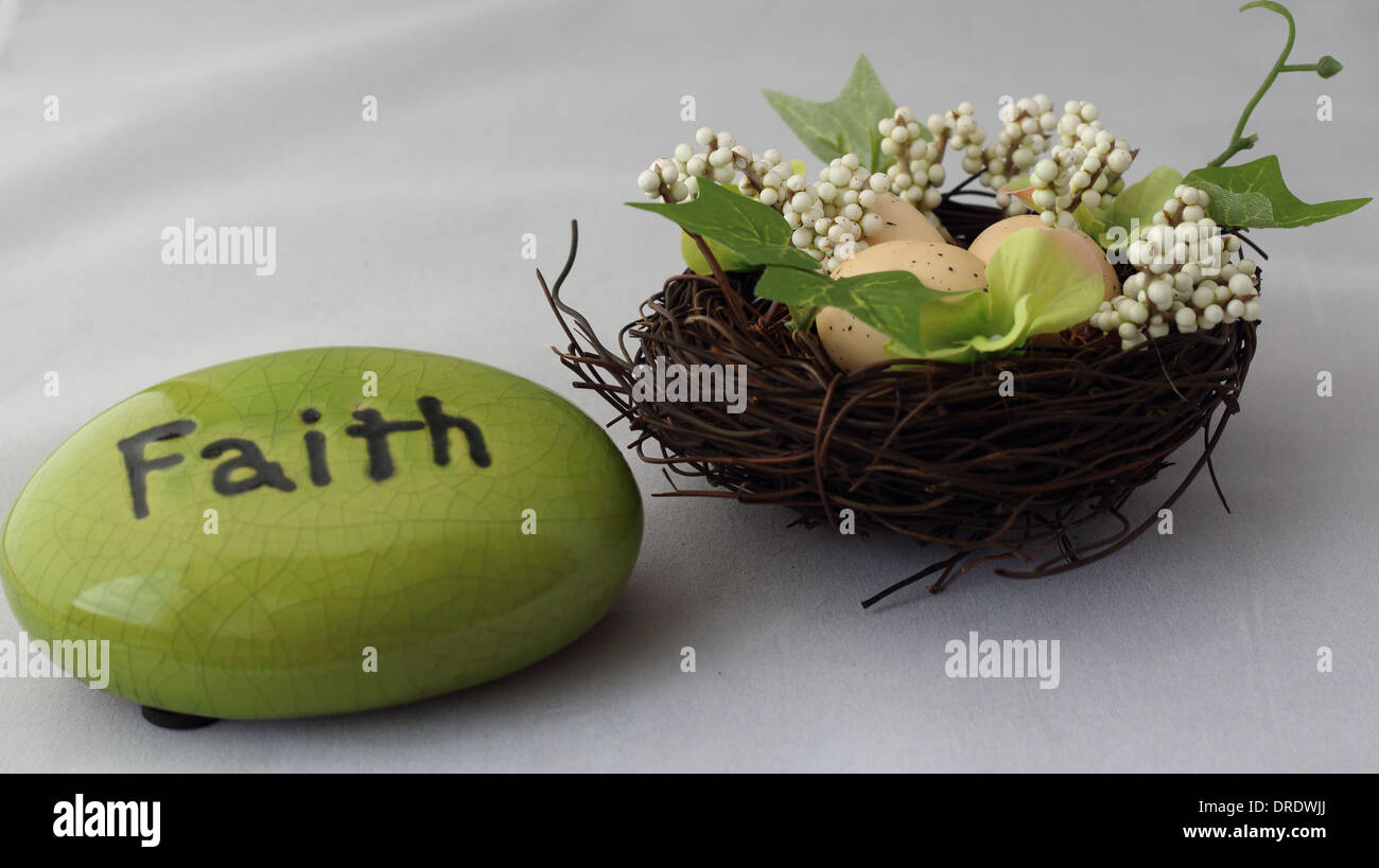 Roccia verde con la parola della fede su di essa accanto a un nido con uova in esso. Foto Stock