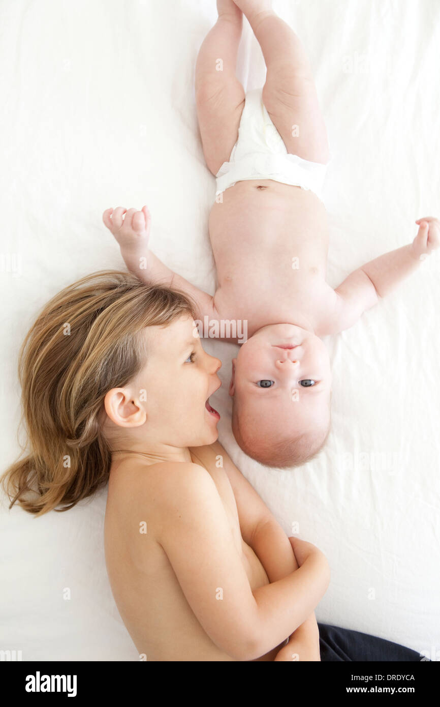 Suor baciando la sua giovane gemelli Foto Stock