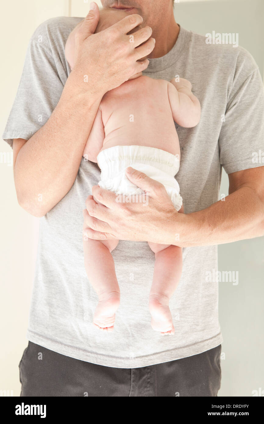 Nuovo papà tenendo il neonato in un pannolino Foto Stock