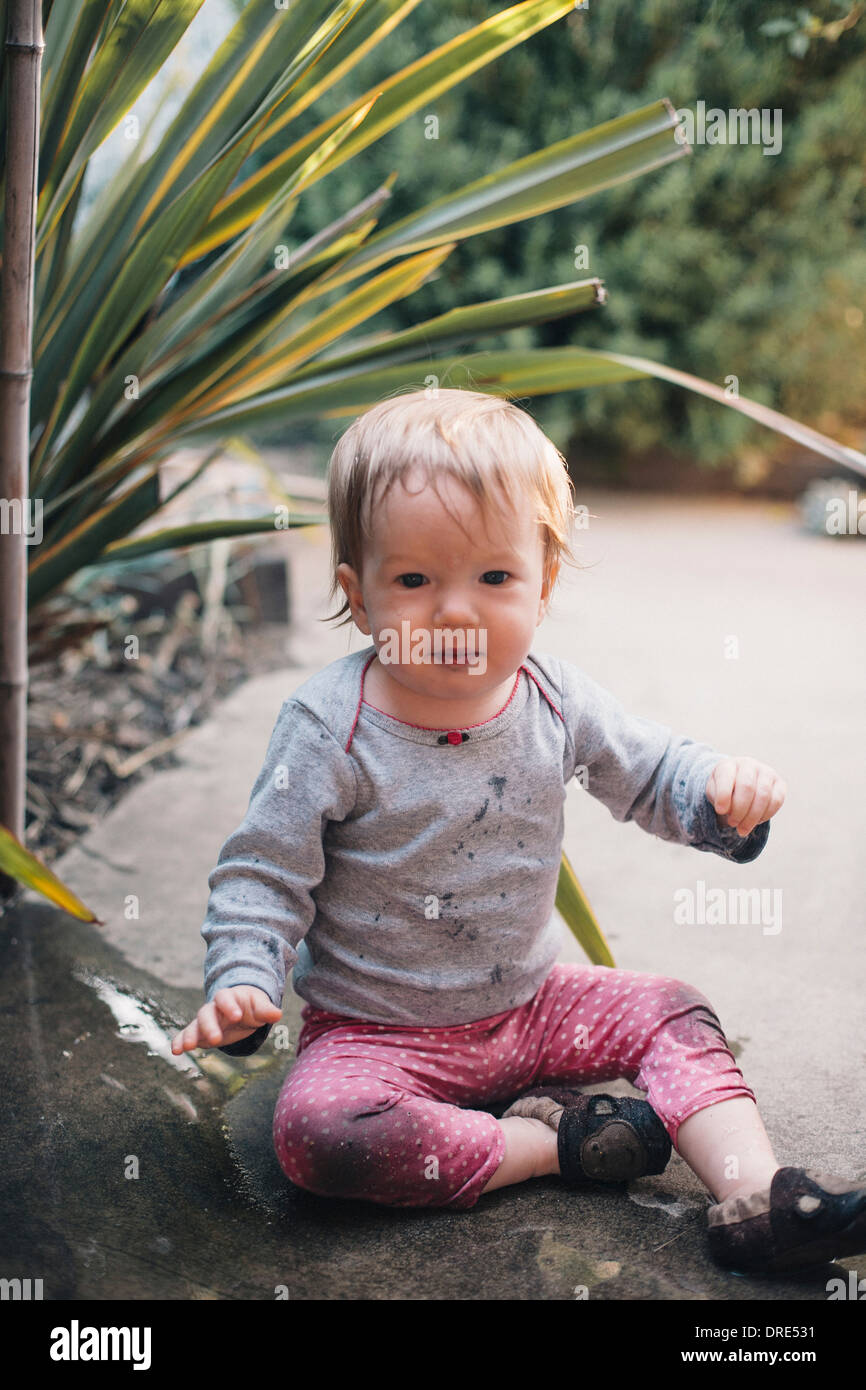 Baby ragazza seduta nel paesaggio Foto Stock