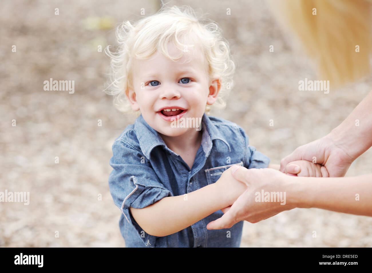 Happy little boy holding donna di mani Foto Stock