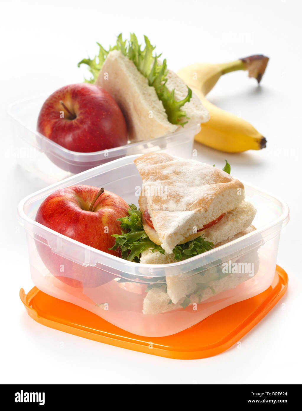 Scatola di pranzo con sandwich e Apple su sfondo bianco Foto Stock