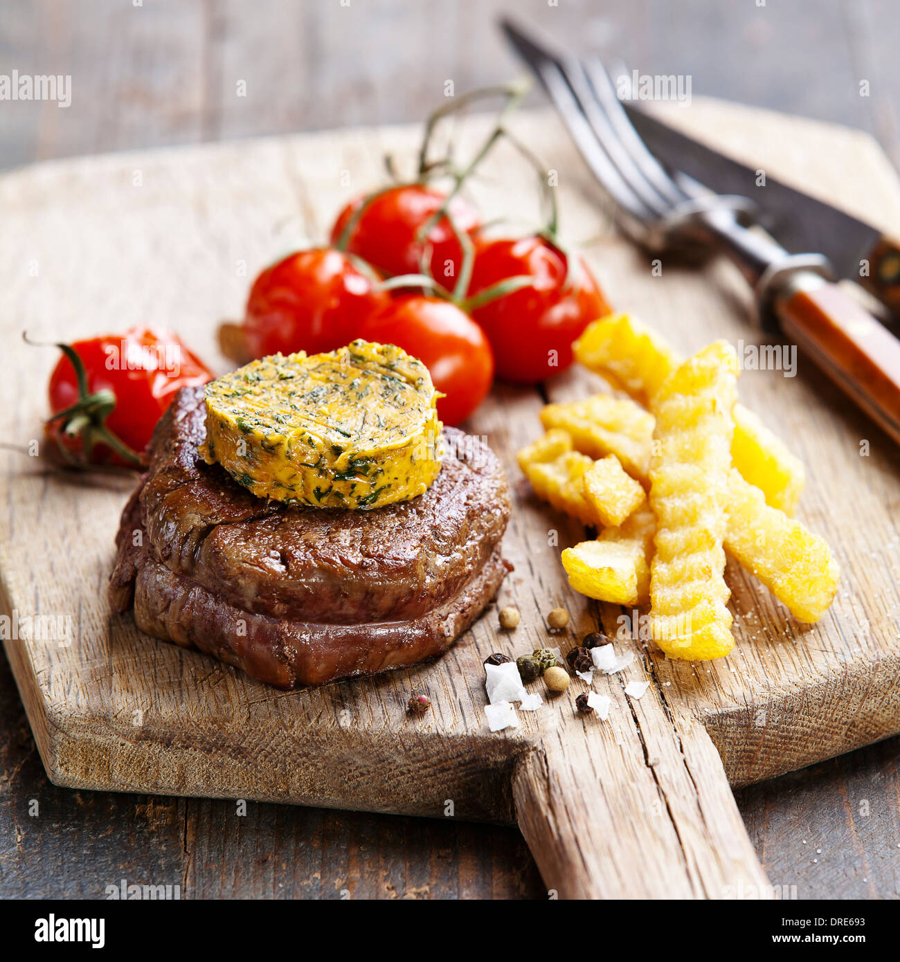 Bistecca di manzo con burro e pomodoro cotto Foto Stock