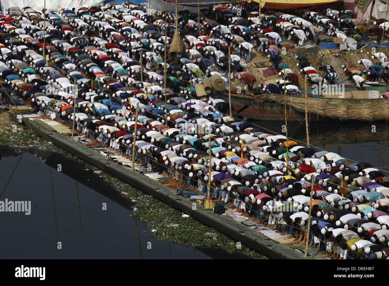 Dacca in Bangladesh 24 Gennaio 2014;migliaia di musulmani frequentano la preghiera Jumma sulle rive del fiume Turag durante il primo giorno dei tre giorni di lunga Congregazione musulmana. Almeno due milioni di devoti da casa e all'estero si sono riuniti in preghiera la massa a partecipare. La prima fase di Ijtema è pronto per iniziare, come coloro che sono venuti al Bangladesh per Ijtema, la seconda più grande congregazione musulmana dopo l'Hajj, sono accolti con strutture di pronto per il loro pellegrinaggio al fiume Turag banca. Credito: zakir hossain chowdhury zakir/Alamy Live News Foto Stock