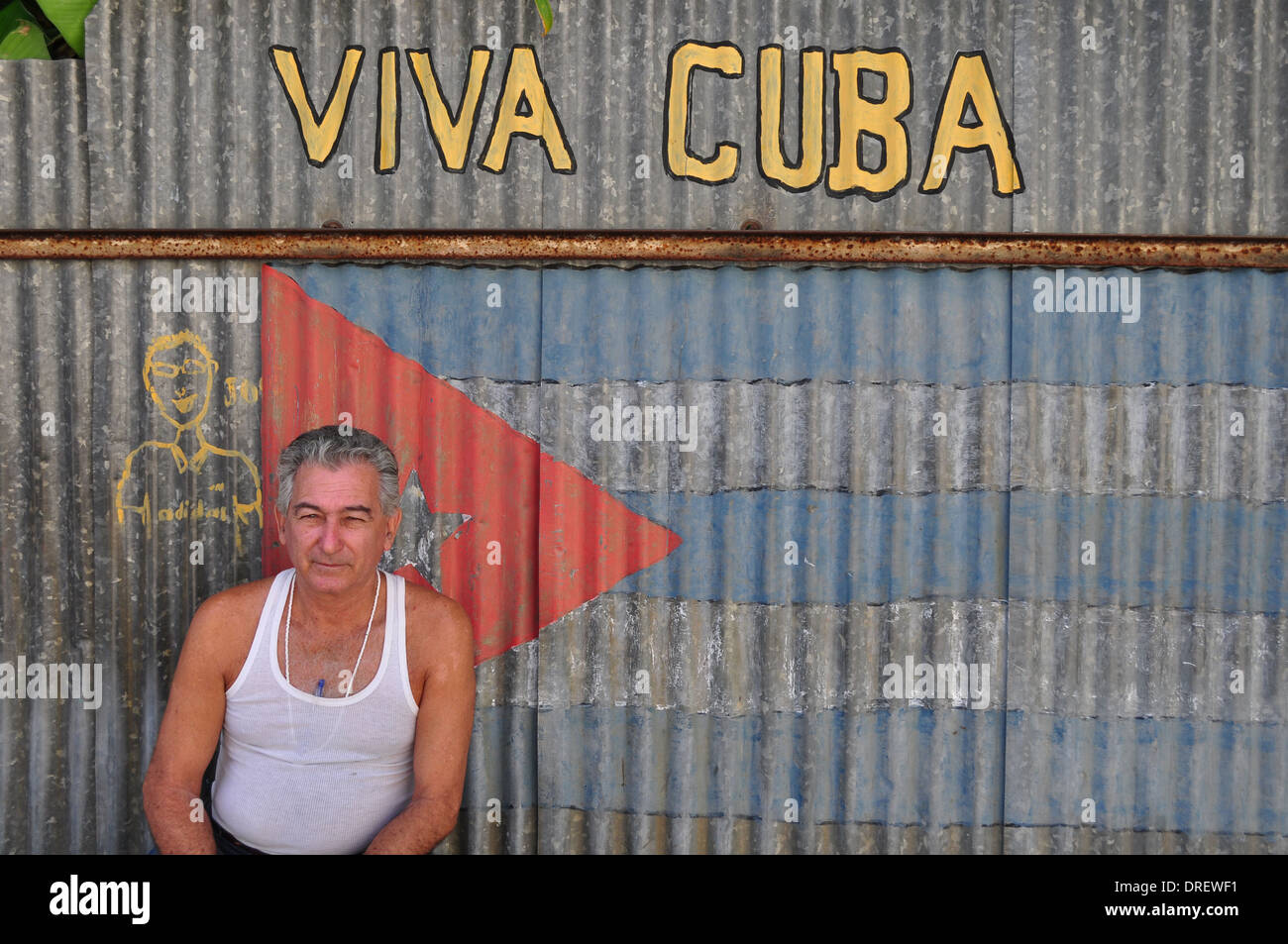 L'Avana, Cuba: uomo si siede accanto a firmare la lettura Viva Cuba in Casa Blanca distretto della città. Foto Stock