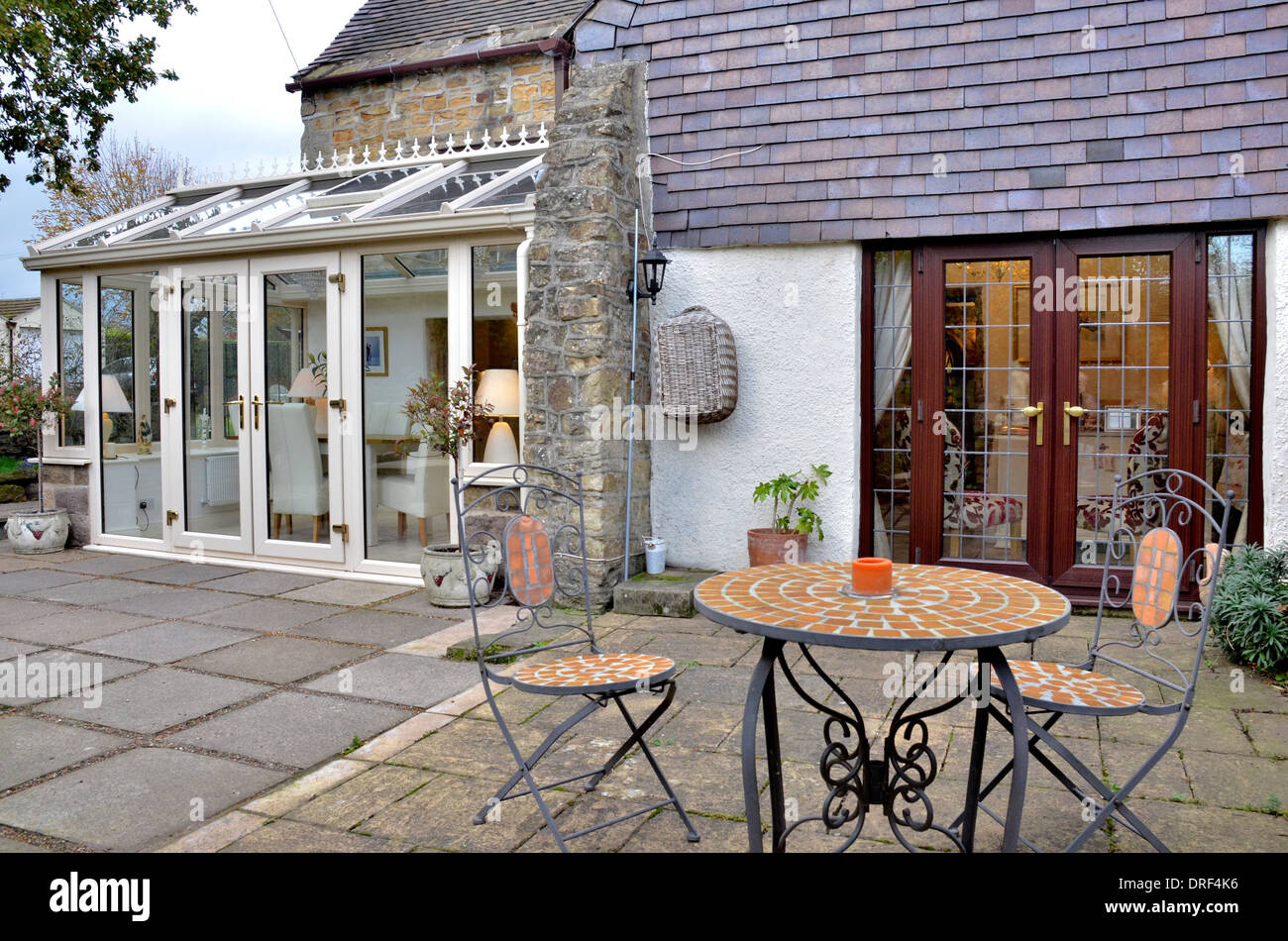 Area patio con porte Francesi, una serra e una cena per due Foto Stock