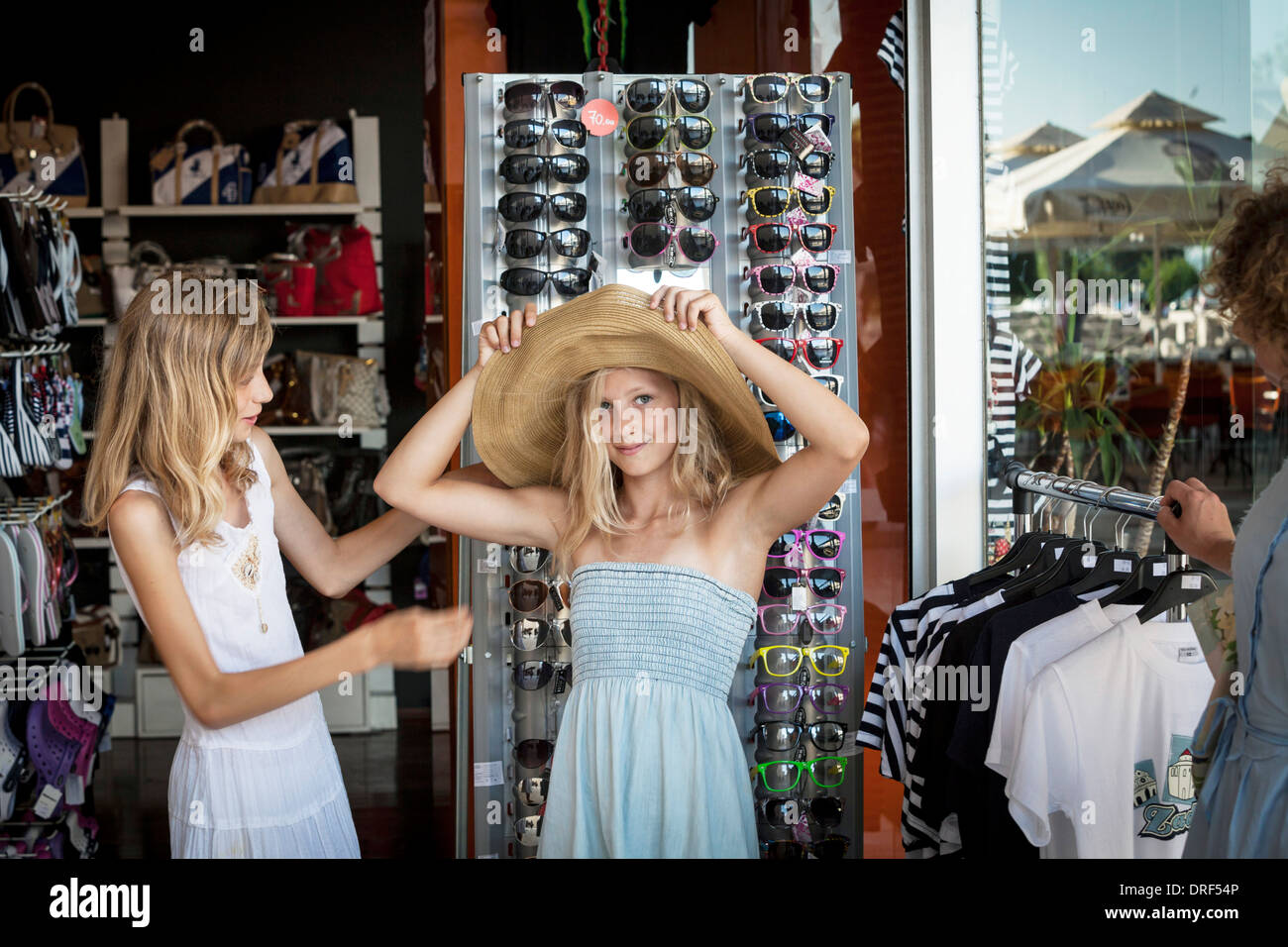 Due ragazze in un negozio di souvenir, cercando un cappello per il sole, Zadar, Croazia Foto Stock