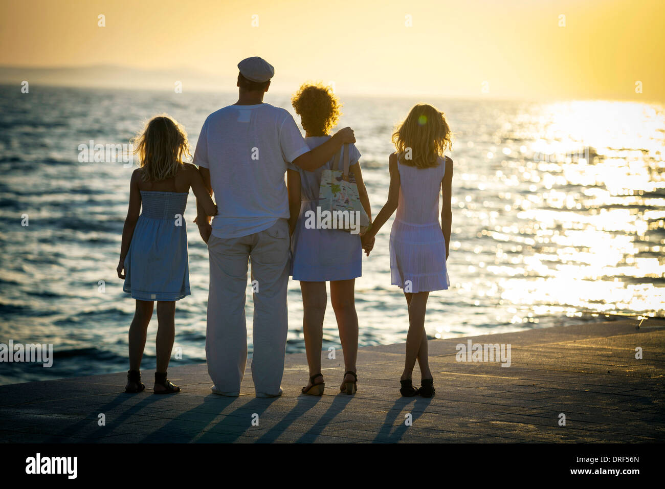 La famiglia sul lungomare, guardando il tramonto, Zadar, Croazia Foto Stock