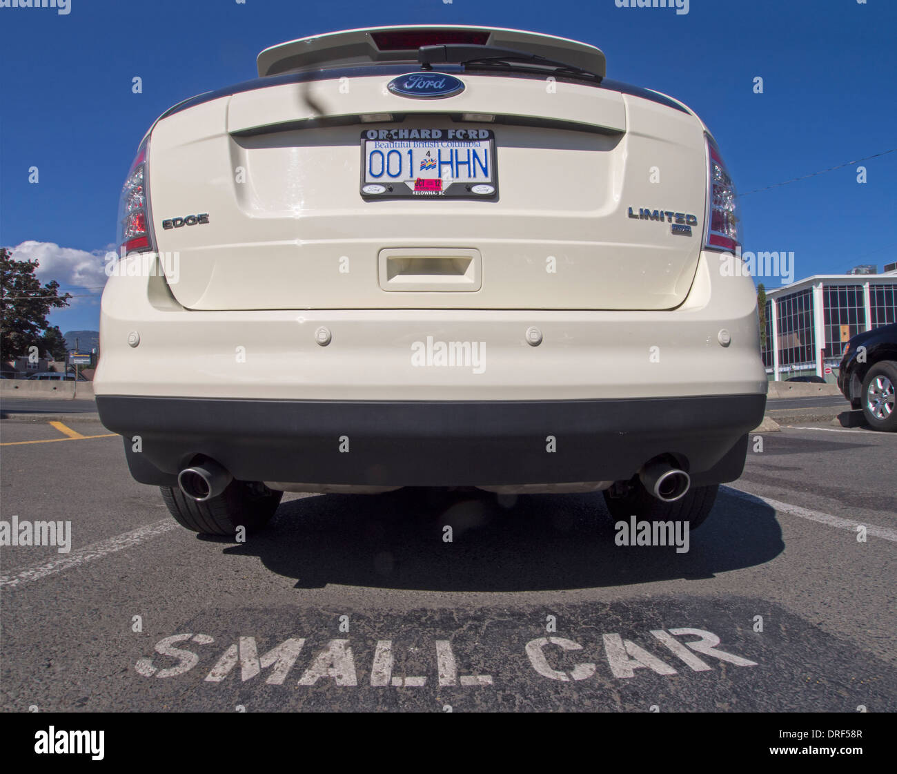 Un grande bianco motore Ford è parcheggiata in uno spazio contrassegnata 'Small' auto. Foto Stock