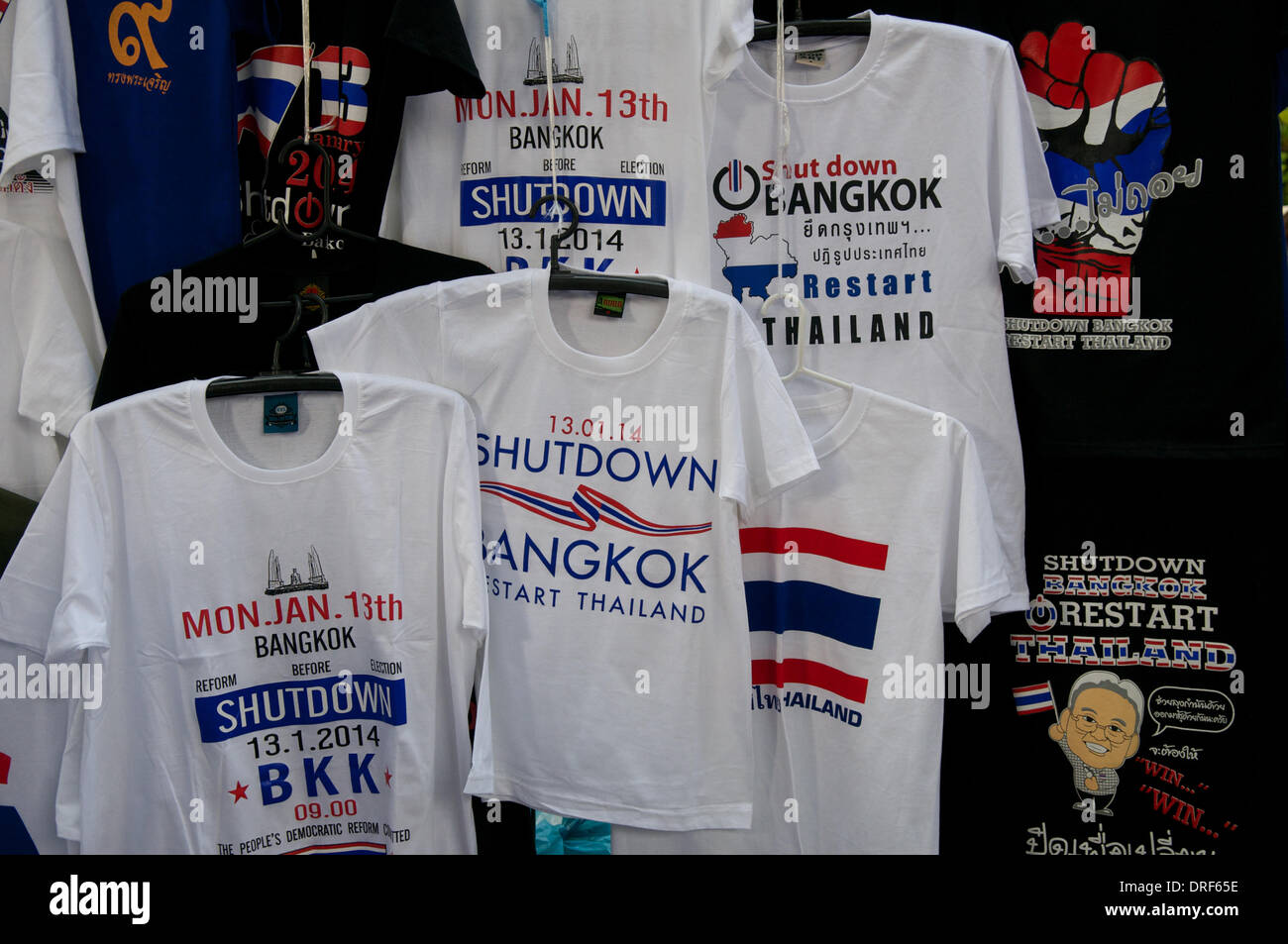 Bangkok, Thailandia. 24 gennaio 2014. Un collage di T-shirt 'Shutdown Bangkok, Restart Thailand' in un negozio pop-up. Il 12° giorno di 'Shutdown Bangkok', i thailandesi hanno trasformato le proteste in un mercato delle pulci. Dopo quasi tre mesi di protesta, ci sono ancora decine di migliaia di manifestanti per le strade di Bangkok che chiedono le dimissioni del primo ministro tailandese Yingluck Shinawatra. "Shutdown Bangkok" è organizzato dal Comitato per la riforma democratica del popolo (PDRC). Crediti: Kraig Lieb / Alamy Live News Foto Stock