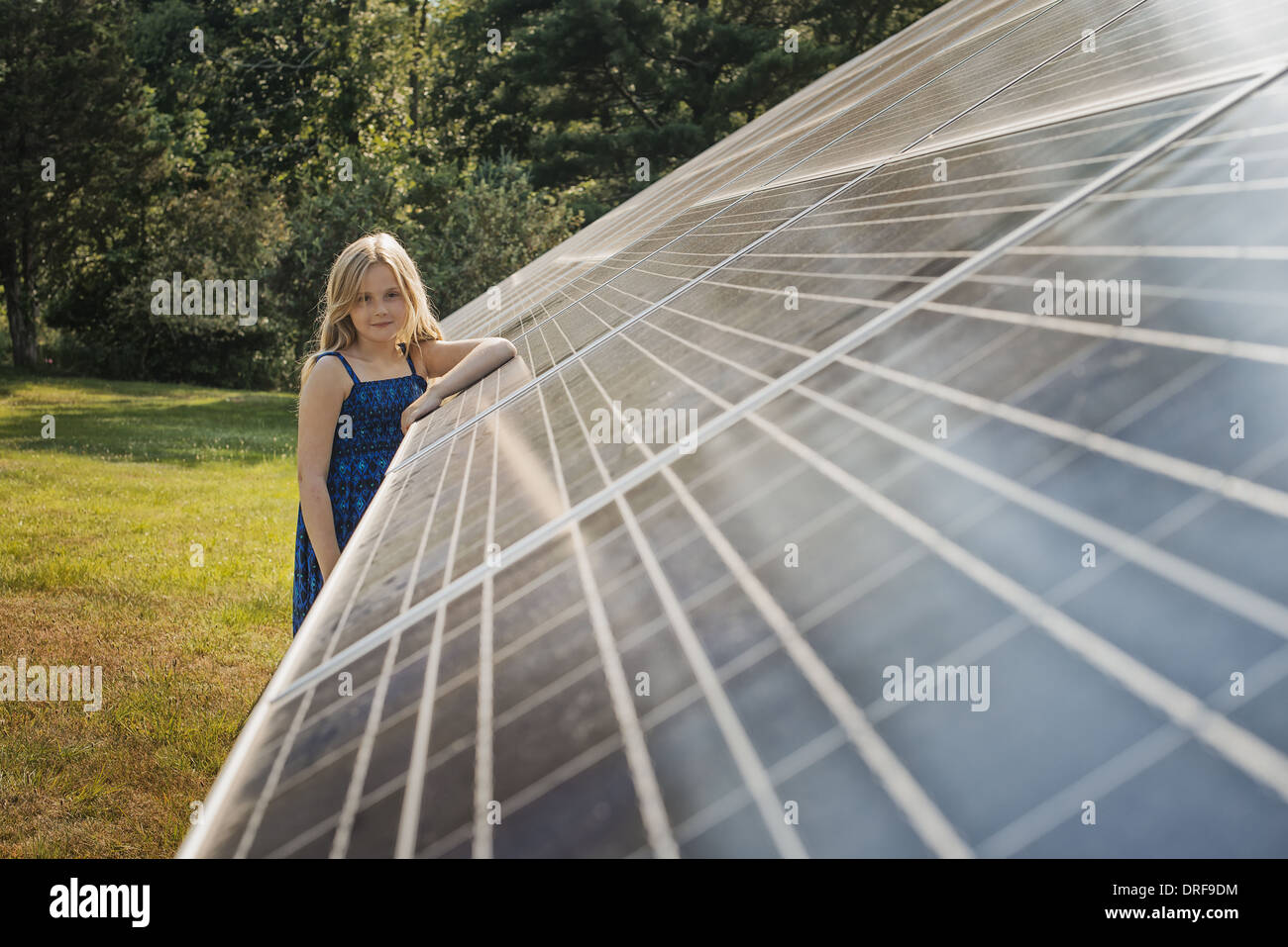 Lo stato di New York STATI UNITI D'AMERICA giovane ragazza in piedi accanto al grande pannello solare Foto Stock