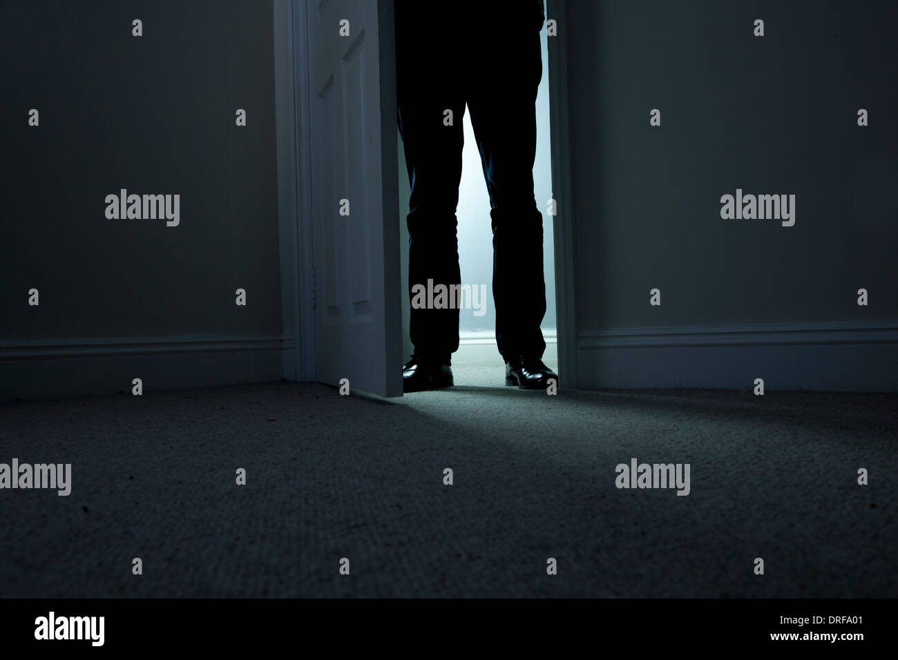 Silhouette di un uomo in piedi al buio in un aperto porta. dark tenebre Foto Stock