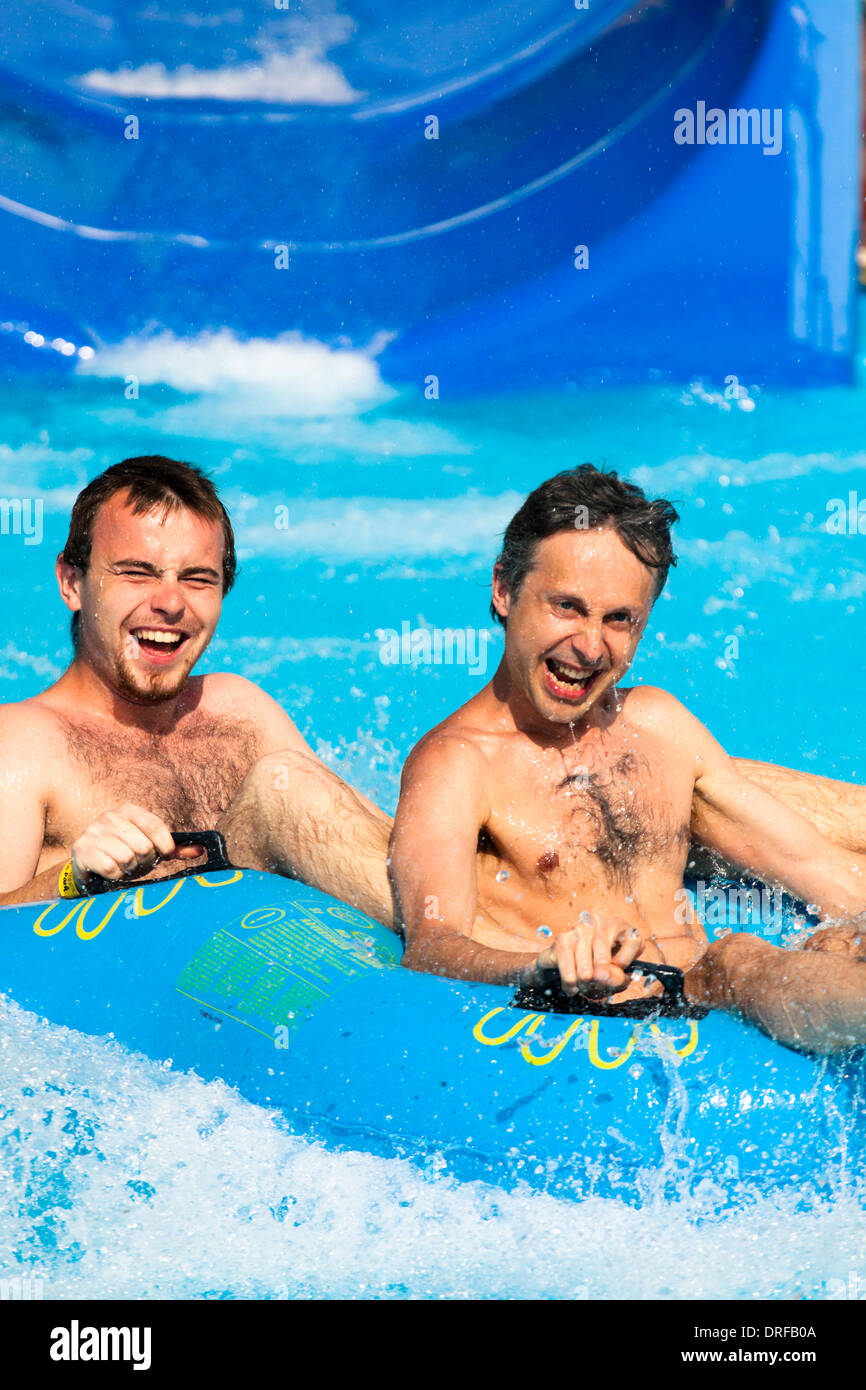 Due uomini si diverte, persone scorrere acqua a Aqua park. Foto Stock