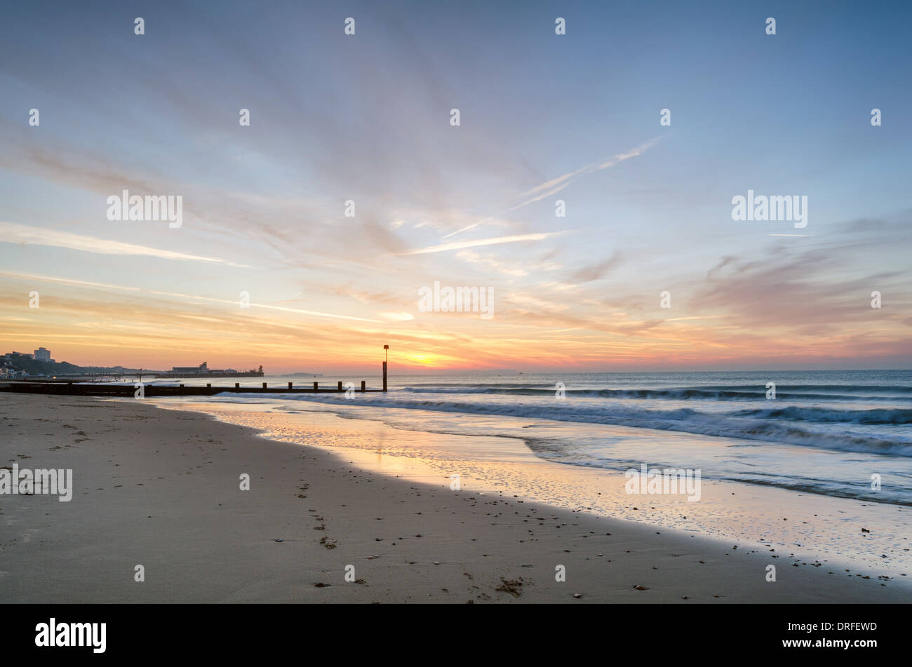 Sunrise a Durley Chine sul Bournemouth Beach con il molo a distanza Foto Stock