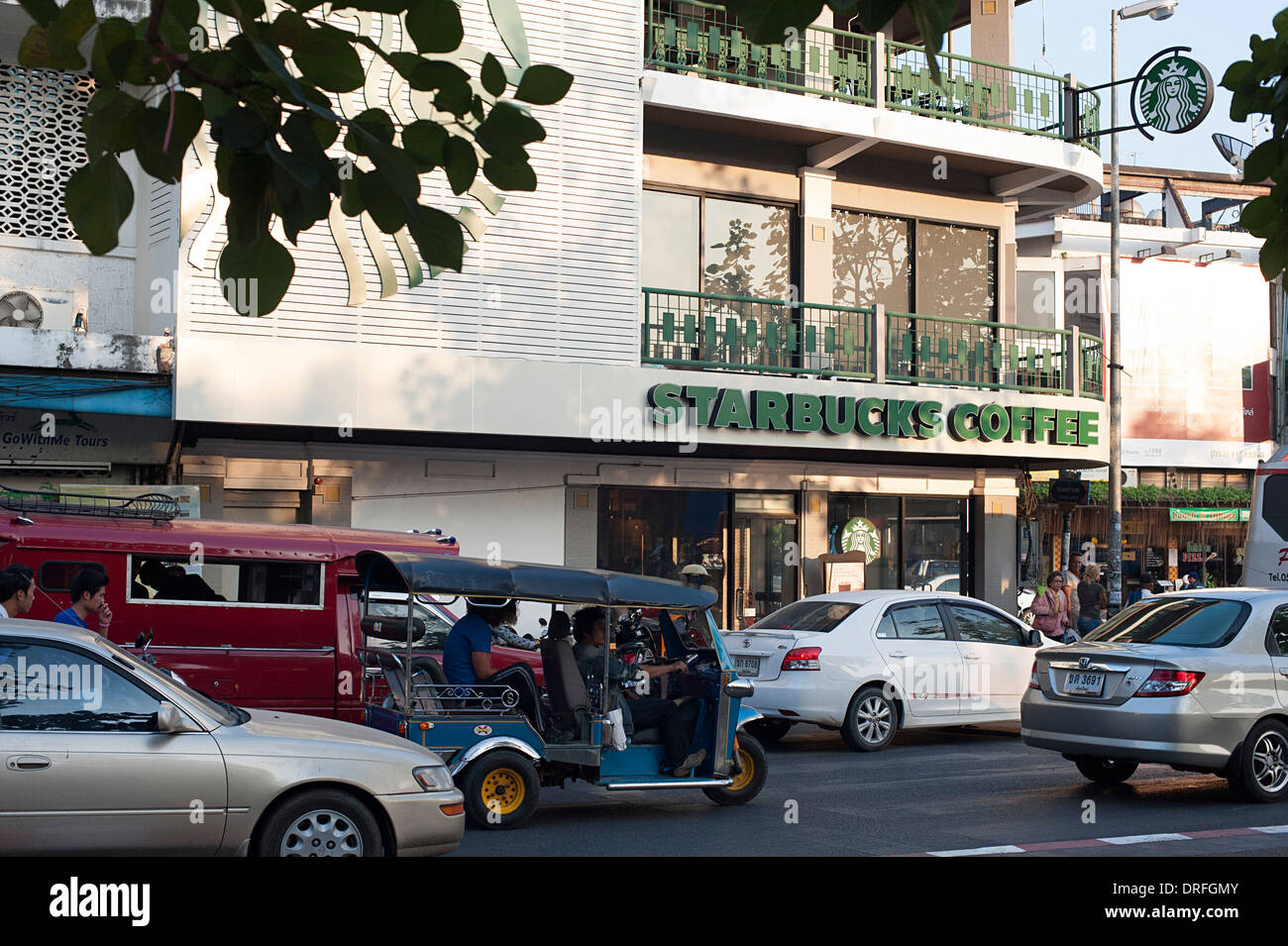 Urban città trafficata strada con Starbucks Coffee shop e un grande cartello. Chiang Mai, Thailandia Foto Stock