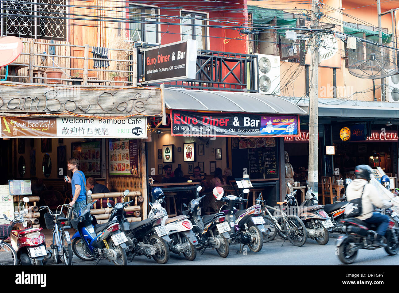 Scena di strada con bar, caffetterie e segni. Chiang Mai, Thailandia Foto Stock