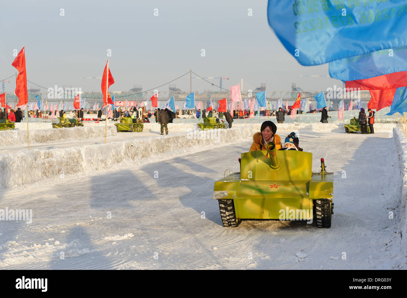 Divertimento invernale sulla congelati Songhua river. Harbin, Cina. La madre e il sole in un esercito in miniatura il serbatoio Foto Stock