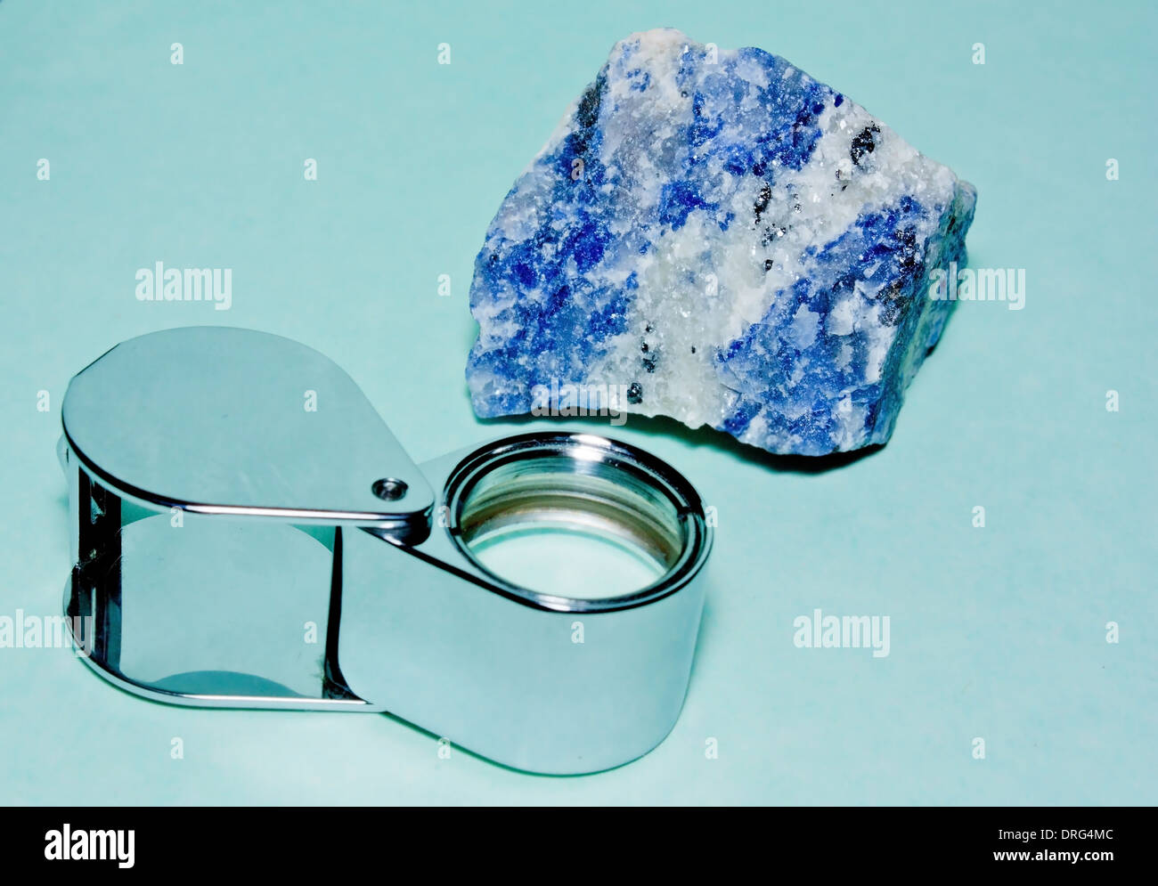Un'immagine del minerale noto come Sodalite e una lente di ingrandimento per assistere con esame Foto Stock