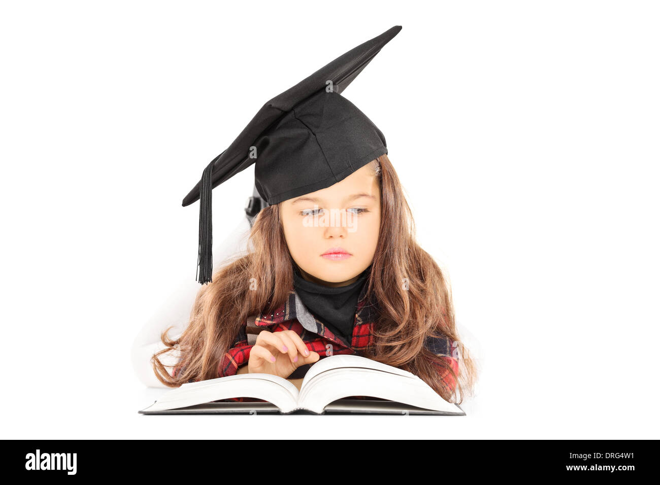 Carino bambina con graduazione hat la lettura di un libro Foto Stock