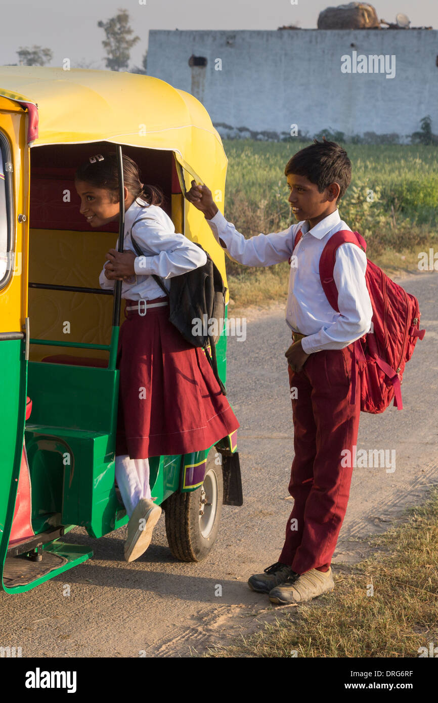 Fratello e Sorella in uniforme scolastica salire in auto rickshaw Foto Stock