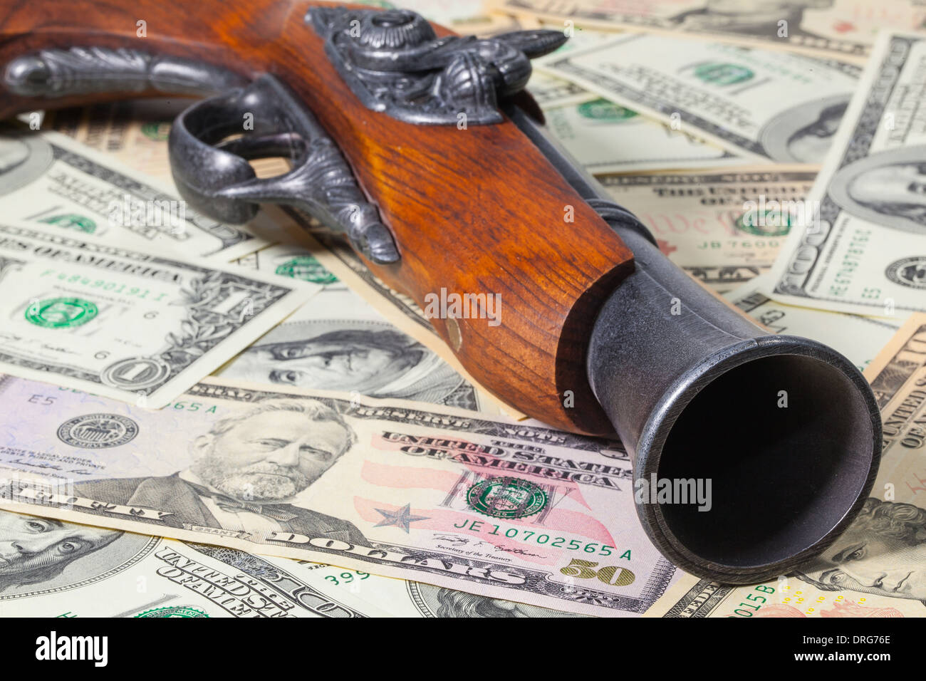 Il vecchio cannone e le fatture del dollaro sul tavolo Foto Stock