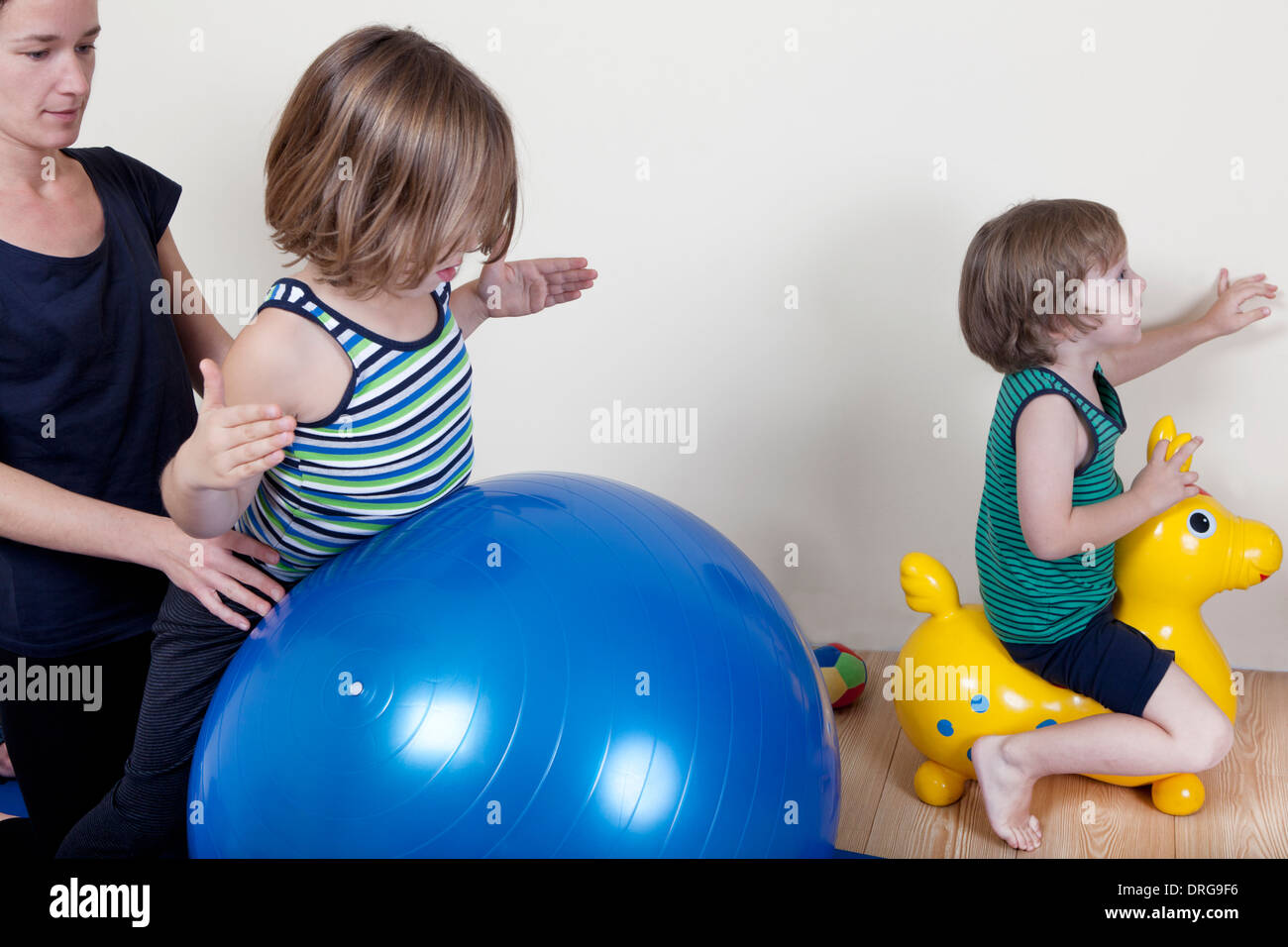 I bambini fare ginnastica su di una sfera, un terapista fisico mostra gli esercizi per la schiena Foto Stock