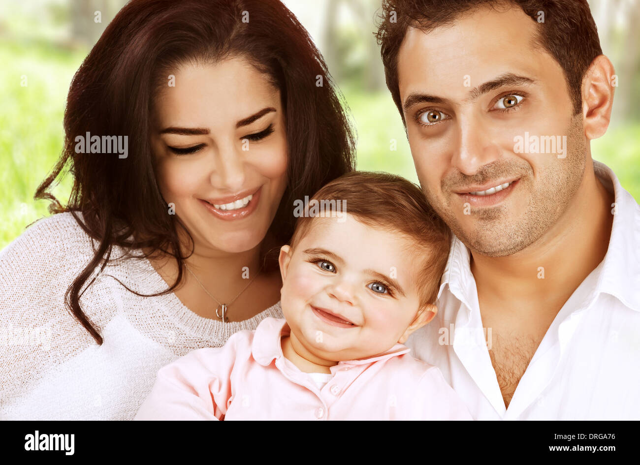 Closeup arabo ritratto di famiglia di trascorrere del tempo all'aperto, giovani genitori con piccola figlia nel parco, di amore e di felicità Foto Stock