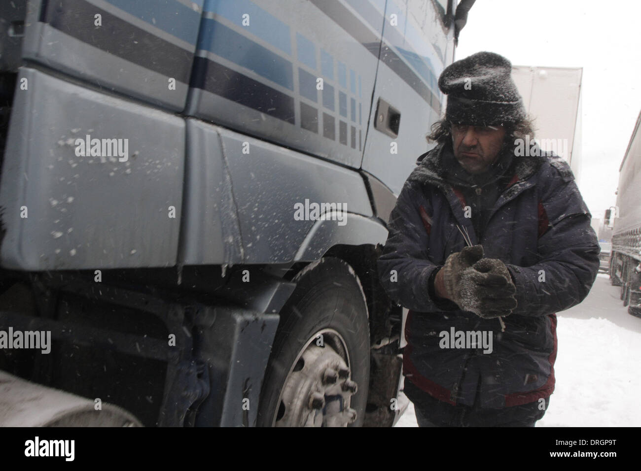 Bucarest, Romania. 26 gen 2014. Un uomo controlla il carrello su una neve-rivestito su strada nella periferia di Bucarest, la capitale della Romania, a gennaio 26, 2014. Secondo il National Weather Amministrazione della Romania, Buzau e altri 2 contee sono sotto il codice rosso avvertenze per le bufere di neve. Tre persone è stato dichiarato morto a causa di neve e blizzard. Credito: Gabriel Petrescu/Xinhua/Alamy Live News Foto Stock