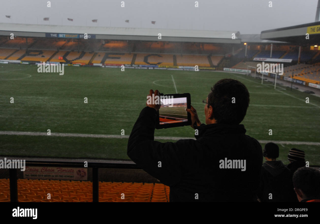 Tempo tempestoso al campo di calcio Port vale a Burslem Stoke, a Trent Staffordshire, con un giornalista che scatta foto su un computer iPad Foto Stock