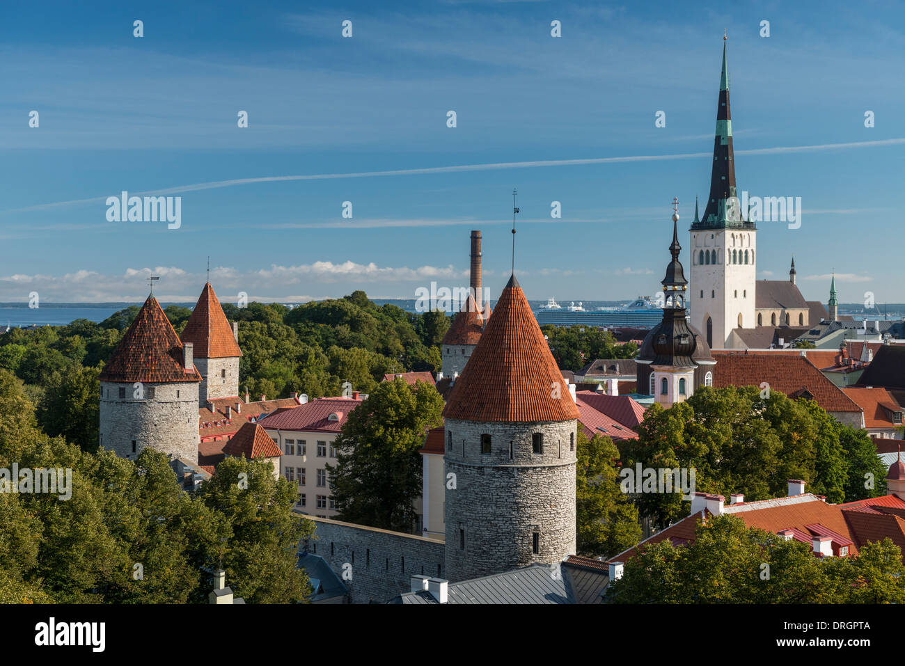 Vista dello Skyline di Tallinn, San dell'Olaf Chiesa e dock Navi da Crociera in la distanza dalla parte superiore città vecchia parete, Tallinn, Estonia Foto Stock