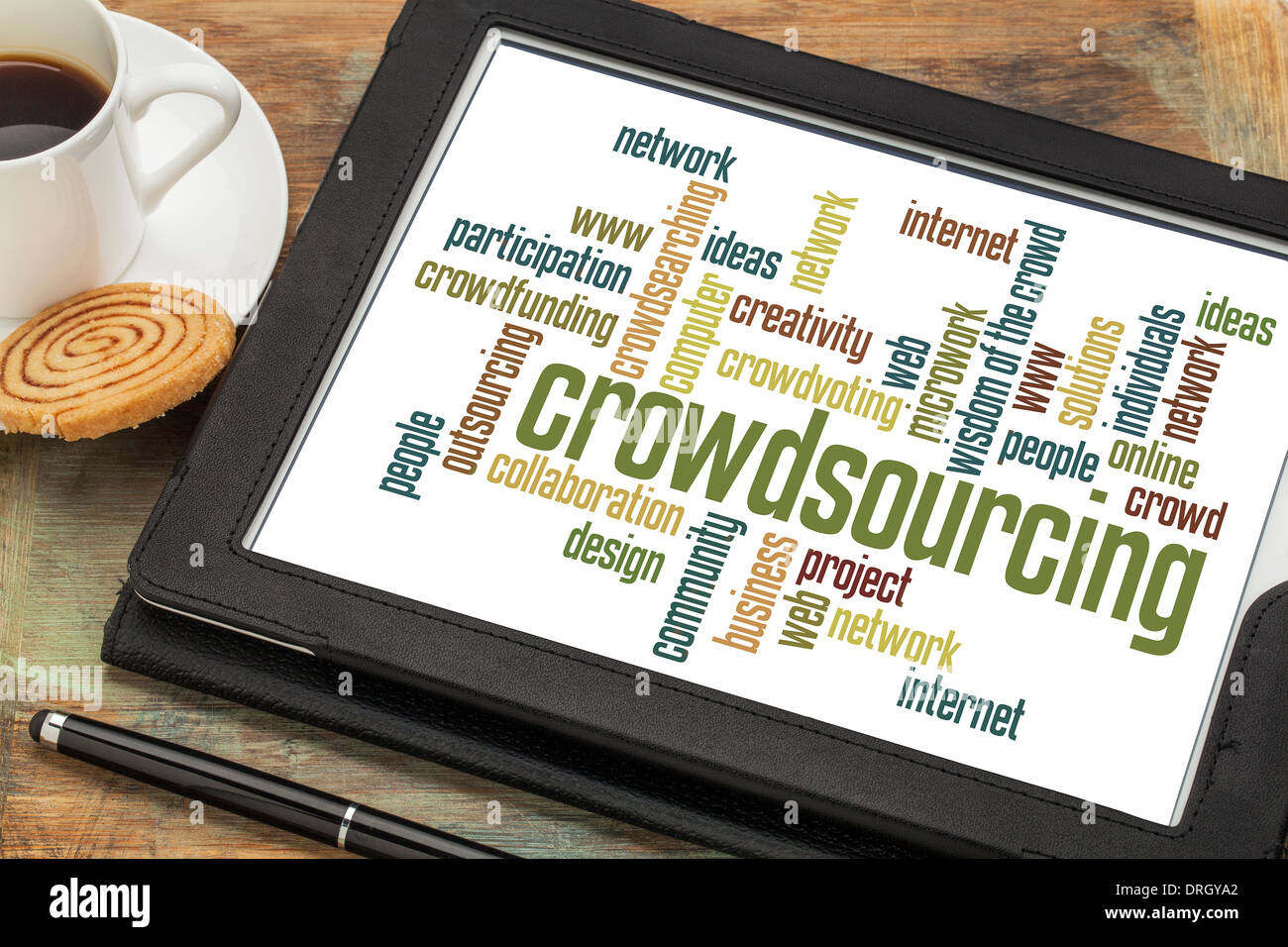 Crowdsourcing word cloud su una tavoletta digitale con una tazza di caffè Foto Stock