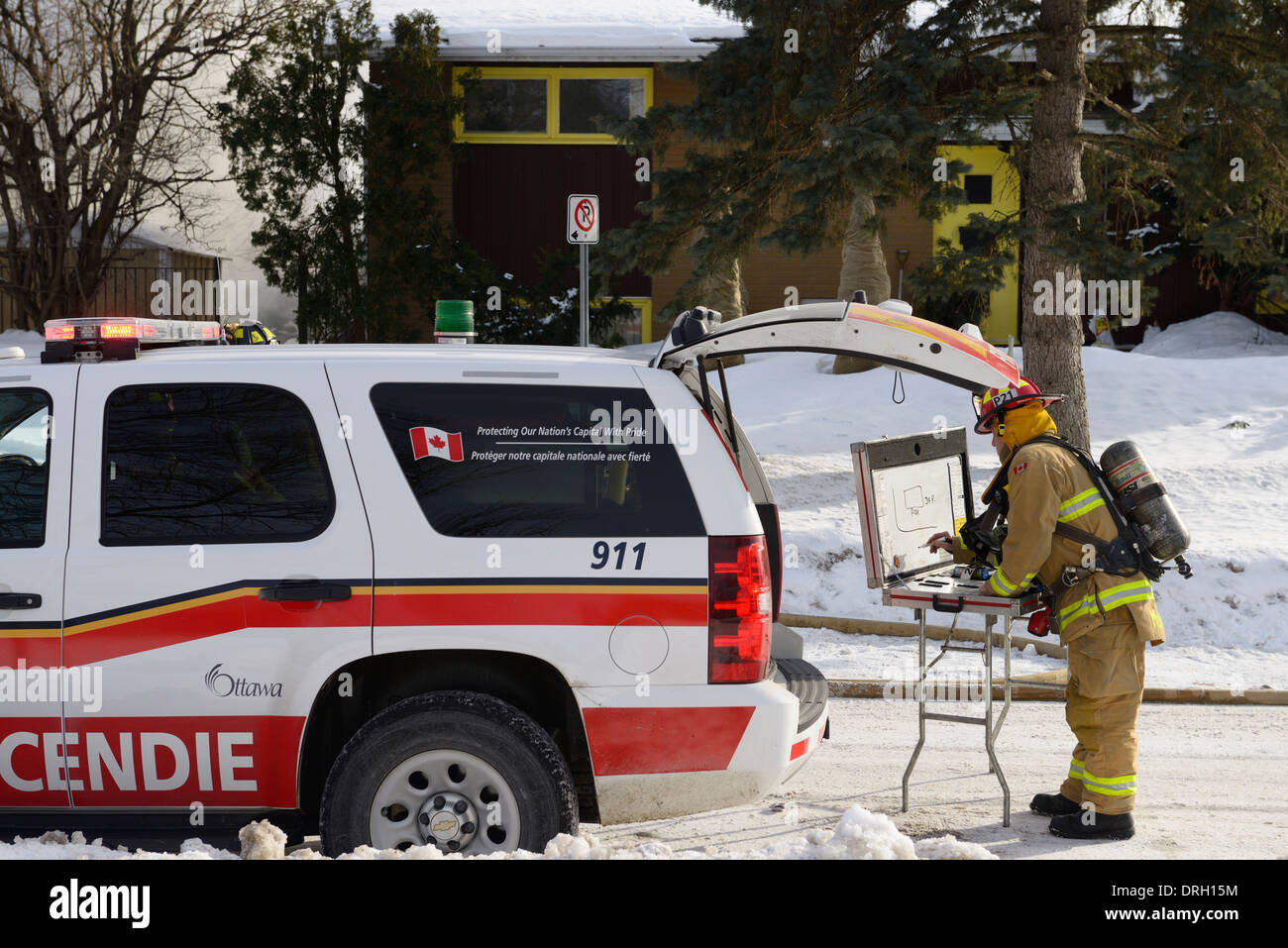 Firefighter capitano impostazione in sede di un centro di comando per una casa strutturali fire a Ottawa Foto Stock